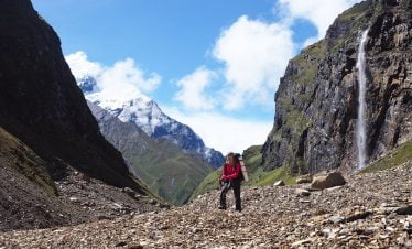 Water fall and female trekker with her happy feet during her Dhaulagiri basecamp trekking adventure