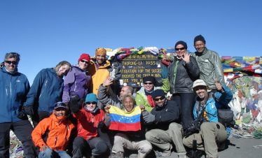 Team at the top of Thorong la pass with cheering celebration