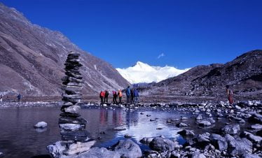 Stack of stone and trekkers on their way towards Gokyo ri in the background