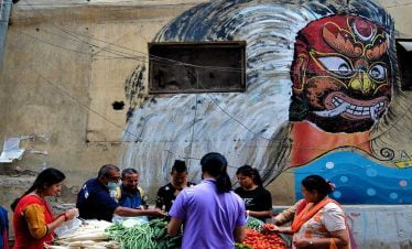 Street vendor selling vegetables at Kathmandu and the street art on the walls