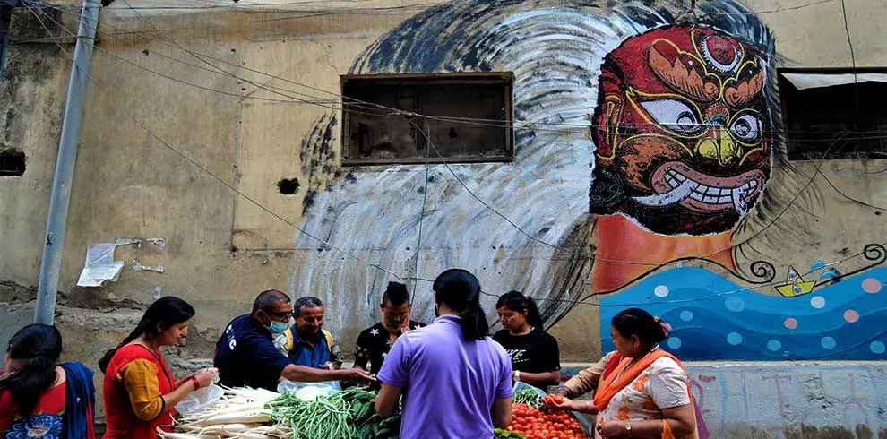Street vendor selling vegetables at Kathmandu and the street art on the walls