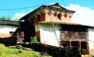 Village kid showing victory sign during trekking by his house towards makalu basecamp trek