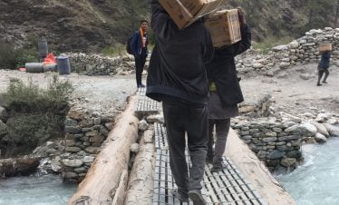 Crossing a small bridge in a big river with their chickens in the basket