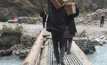 Crossing a small bridge in a big river with their chickens in the basket