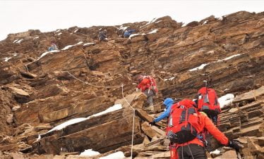 Trekking along Tasi lapcha pass is not easy - trekkers passing with ropes