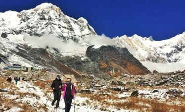 Annapurna south seen in the morning and trekkers getting down from Annapurna base camp trek