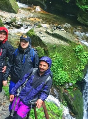 Boys pose at waterfall site in the rain