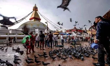 Boudhanath stupa and a man feeding birds at kathmandu