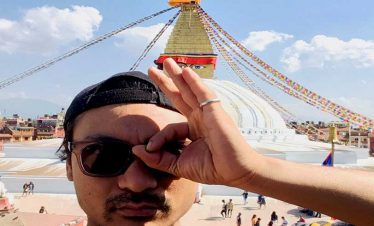 Tourist trying to highlight the eye of Boudhanath stupa on his sightseeing tour