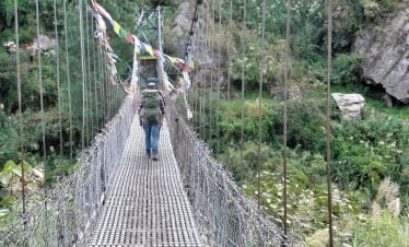 Starting Langtang circuit trek after crossing the bridge filled with prayer flags