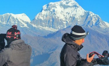 taking pictures at the top of poonhill