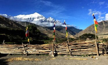 Dhaulagir range, prayer flag and local house in the sight while riding to mustang