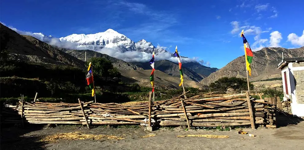 Dhaulagir range, prayer flag and local house in the sight while riding to mustang