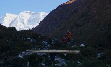 trekker, potter and the long wood beneath the beauty of the white Himalaya seen in Manaslu Bhimtang trek route