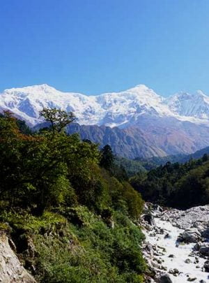 River coming from Bhimtang village and trekkers staring at the white mountains