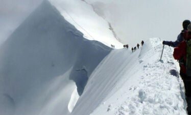 climbers walking through snowy trail