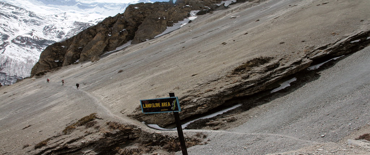 Trekkers walking along a landslide-prone trail on the way to tilicho lake nepal